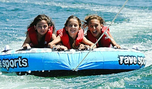 Three girls from Los Angeles enjoying a tubing activity at Aloha Beach Camp summer camp
