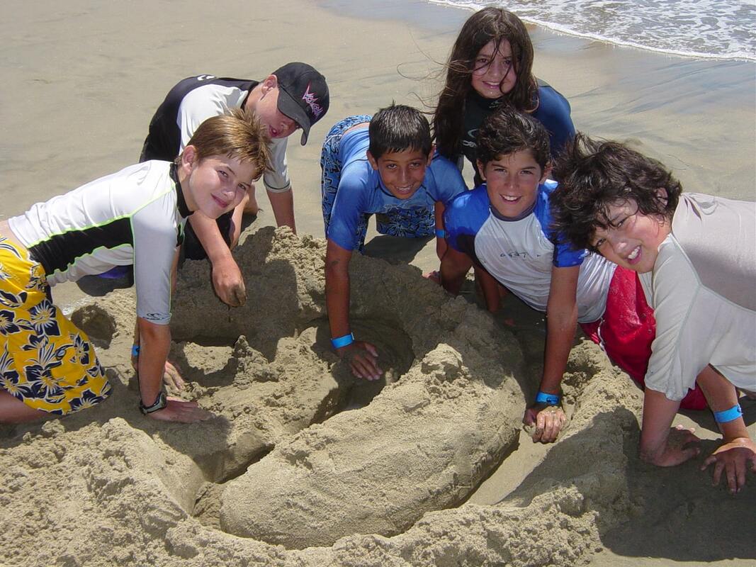 6 campers making a sandcastle at Aloha Beach Camp on Zuma Beach