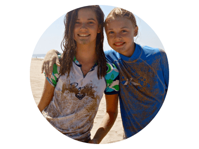 Two female teenage campers from Beverly Hills covered in sand and smiling at Aloha Beach Camp Day Camp. These girls are just two of dozens and dozens of happy campers from the Beverly HIlls are who enjoy Aloha Beach Camp program each summer.