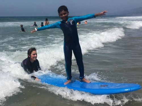Camper from the Pacific Palisades taking a surfing lesson from his Aloha Beach Camp surf instructor.
