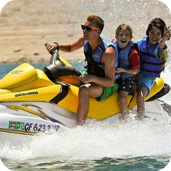 Aloha Beach Camp counselors and two campers riding a jet ski at Castaic Lake