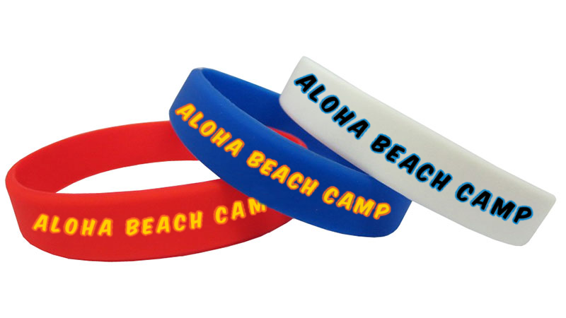 Red, blue, and gray color coded wristbands designating how deep campers are allowed to swim in the ocean at Aloha Beach Camp.