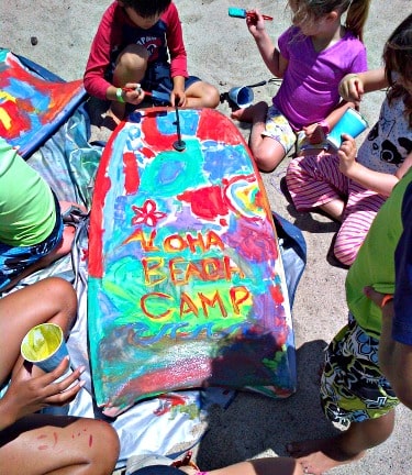 Campers painting a boogie board at Aloha Beach Camp