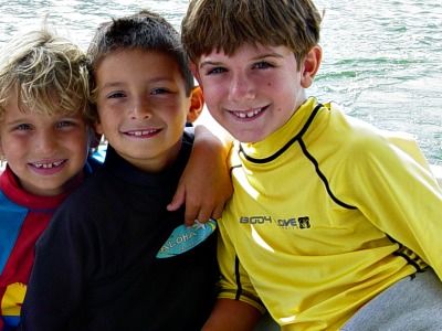 Three boys from the Pacific Palisades playing on the beach and enjoying their Aloha Beach Camp day camp experience together.