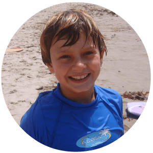 Boy on the beach wearing an Aloha Beach Camp rash guard. Aloha Beach Camp is L.A.'s only accredited summer beach day camp for kids and teens. Accredited camps set the standard among all camps for safety, quality and fun.
