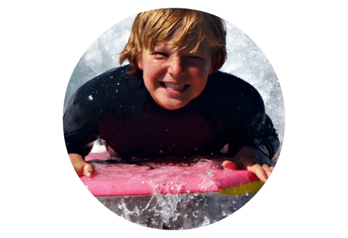Teenage boy boogie boarding at Aloha Beach Camp, one of the best Los Angles summer camps for teens.