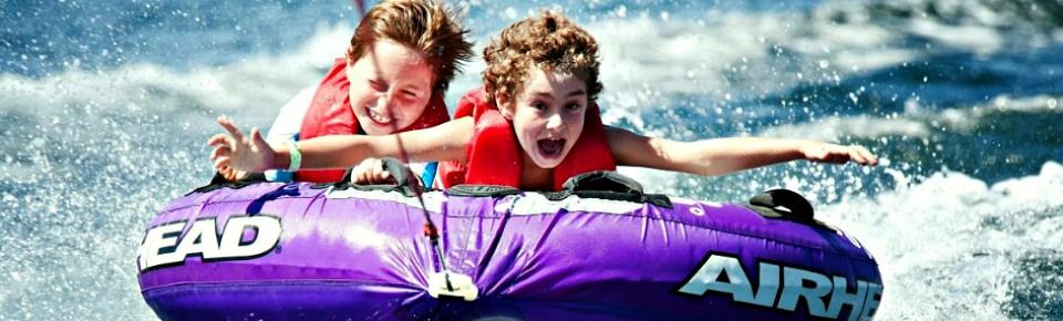 Two 12 year old campers glide through the water on their innertube at Aloha Beach Camp's Castaic Lake activity location. Campers visit Castaic Lake for tubing and other lake acvities every Wednesday during the summer.