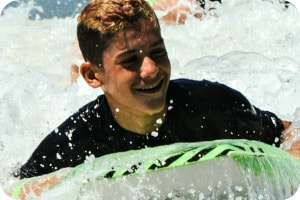 Teenage boy boogie boarding at summer camp.