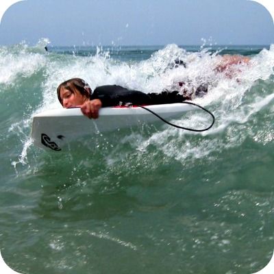 Teenage boy from Calabasas boogie boarding a big wave at Aloha Beach Camp.