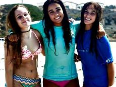 Three teenage girls hanging out together on the beach at Aloha Beach Camp's High Action Summer Camp in Los Angeles, CA