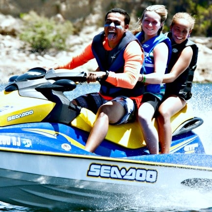 Two female campers jet skiing with their camp counselor at Aloha Beach Camp.