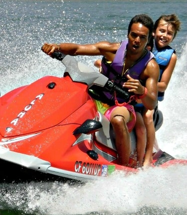 Boy and his camp counselor jet skiing at Aloha Beach Camp