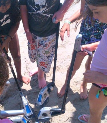 Five campers playing with metal detectors on the beach at Aloha Beach Camp