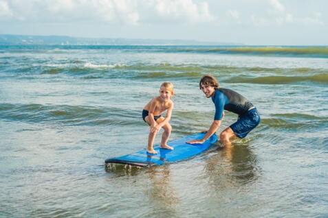 Boy learning how to surf at summer camp