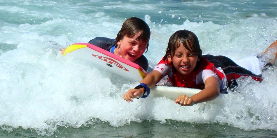 Two boys from the San Fernando Valley boogie boarding at Aloha Beach Camp