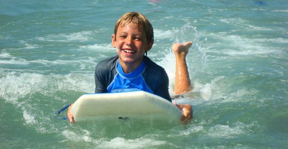 Boy from Sherman Oaks riding on his boogie board at Aloha Beach Camp.