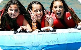 Three teenage girls from the San Fernando Valley enjoying summer camp together on their innertube at Castaic Lake.