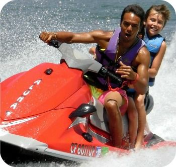 Camper and his camp counselor riding a jet ski at Aloha Beach Camp
