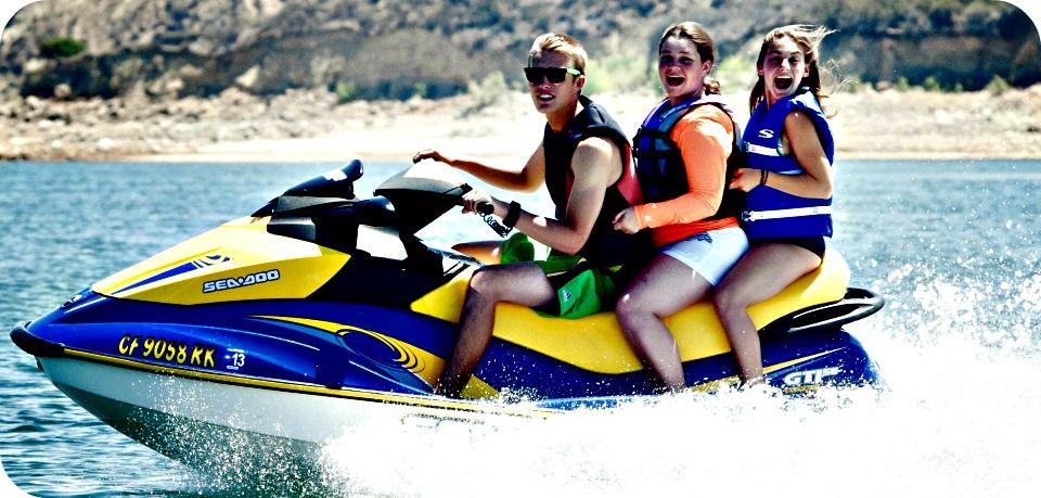 Two teenage girls and their camp counselor jet skiing at Aloha Beach Camp.