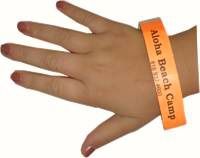 Orange wristband wrapped around child's wrist with Aloha Beach Camp's name and phone number imprinted on it for added camper safety at the beach.