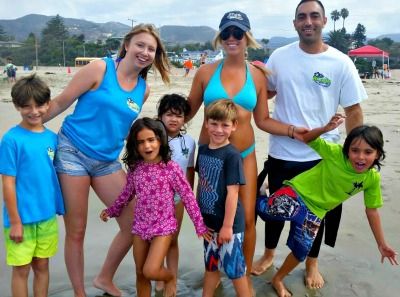 Three camp counselors and five young camper children enjoying Aloha Beach Camp's Keiki Camp program on Zuma Beach, Malibu, summer 2021.